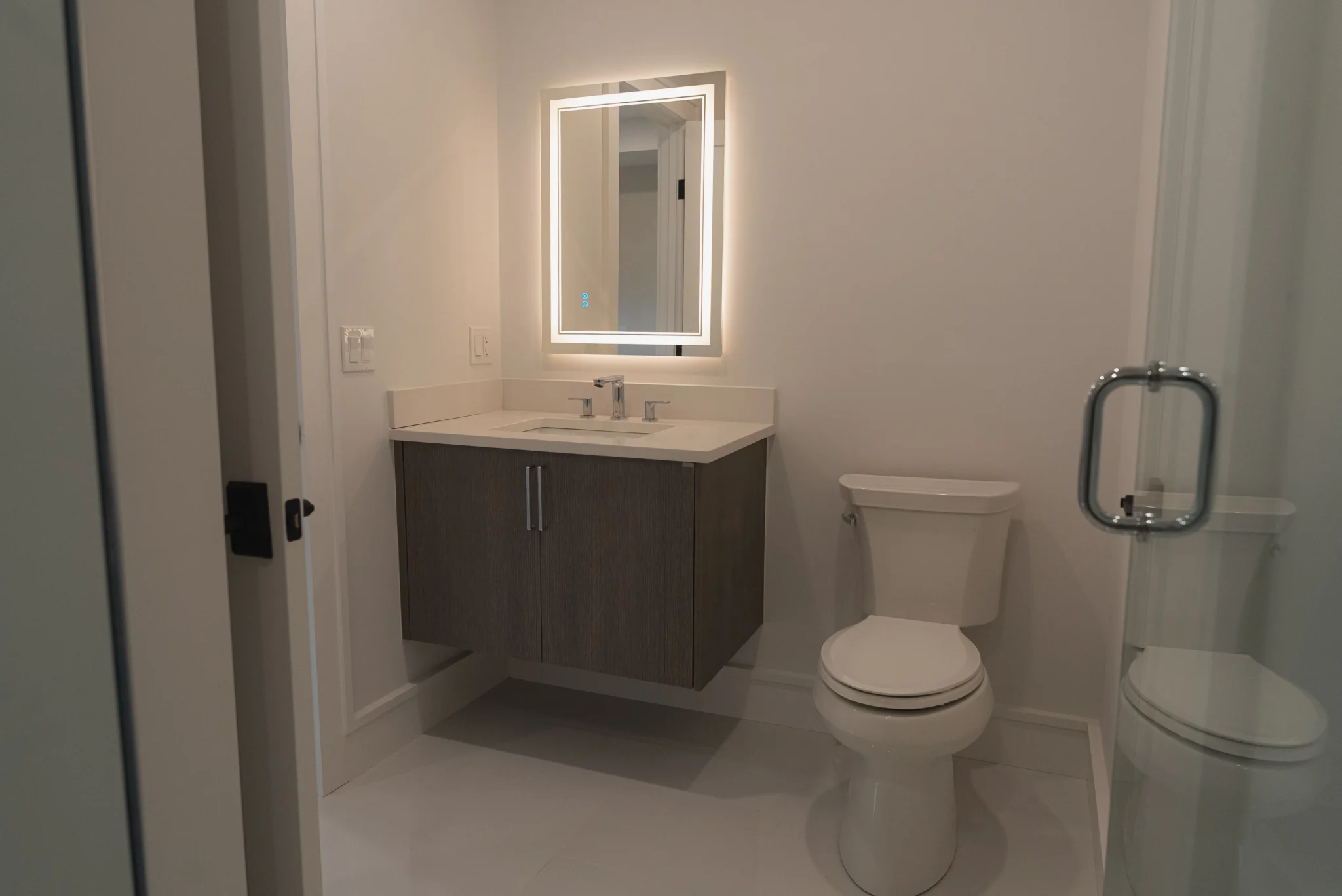 Compact modern bathroom with floating vanity, LED mirror, and minimalist design